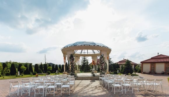 View of guest seats and ceremonial weddding archway on the sunny say, chiavari chairs