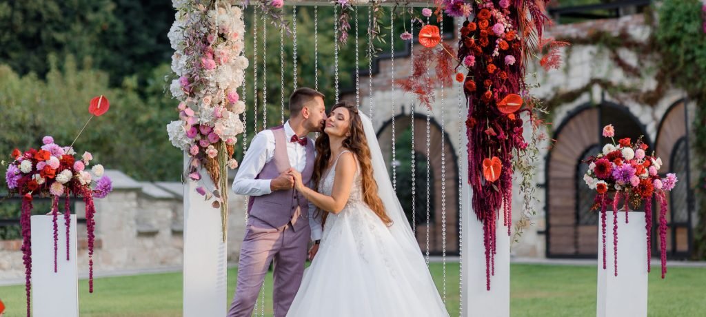 Wedding archway on the backyard and happy wedding couple outdoors before wedding ceremony